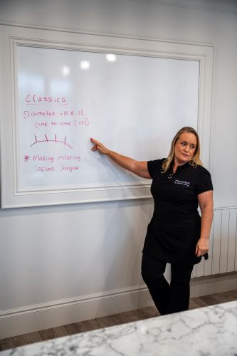 Beauty educator qualification Ireland, tutor demonstrating hair cutting technique to two students